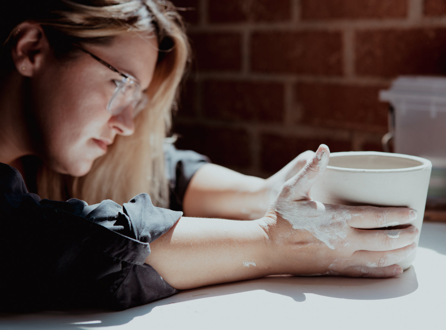 Ceramic Artist Heather Renee works closely on a piece.